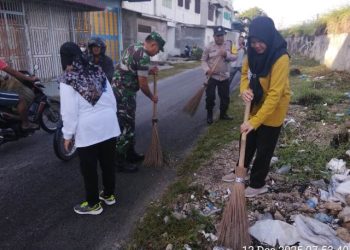 Bhabinkamtibmas, AIPTU Alexander dan AIPTU Wellinton Nababan, mengikuti gotong royong bersama, di Jalan Jintar Saragih, pada Jumat (12/12/2025) pagi.