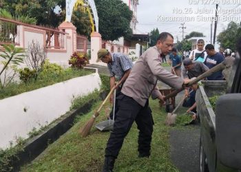 Polsek Sianțar Barat gotong royong bersama masyarakat, di Jalan Merpati Pematangsianțar, pada Jumat (5/12/2025) pagi.