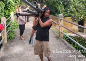 Foto terduga pelaku memegang barang bukti.