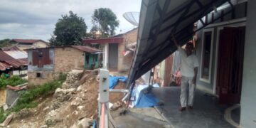 Salah seorang warga yang teras rumahnya longsor