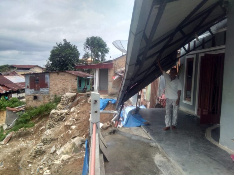 Salah seorang warga yang teras rumahnya longsor