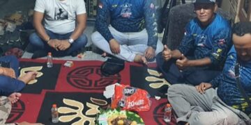 Andika Prayogi Sinaga SE berkaos putih  saat melakukan pertemuan