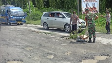 Personel yang mengevakuasi material di badan jalan