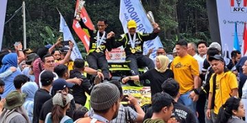 Wagubsu menggunakan topi kuning didampingi Co Driver sebagai juara