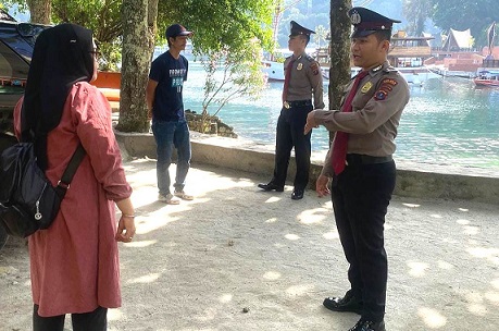 Personel berbincang dengan pengunjung di lokasi wisata