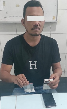 Tersangka pegang barang bukti