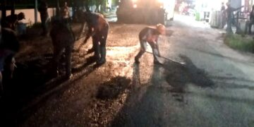 Pekerja meratakan badan Jalan Pane yang sempat dikorek