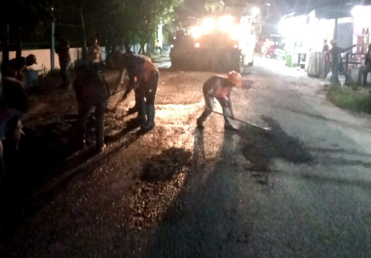 Pekerja meratakan badan Jalan Pane yang sempat dikorek