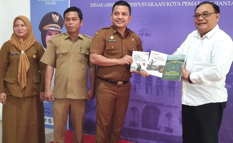 Dr Sarbudin Panjaitan serahkan buku kepada Kepala Perpustkaan