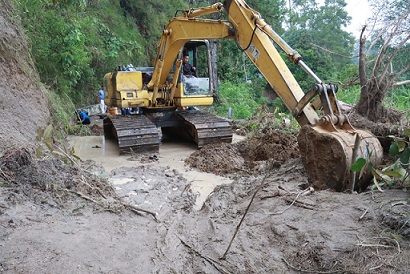 Pembersihan material longsor menggunakan alat berat