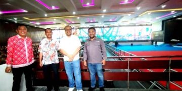 Pemko Siantar dan pihak Universitas HKBP Nommensen dengan latar belakang aula lokasi tinju PON XXI
