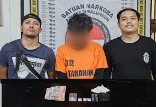 Tersangka dan barang bukti diapit petugas