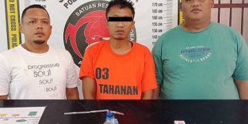 Tersangka dan barang bukti diapit petugas