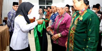 Wakil Walikota pakaikan toga Dewan hakim kepada Ketua Dewan Hakim MTQN 57, Drs H M Ali Lubis