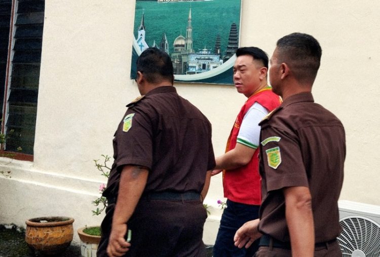 Terdakwa  diapit petugas Kejaksaan
