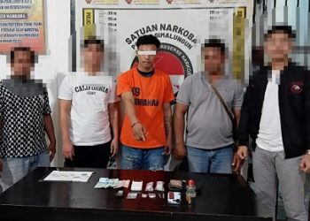 Tersangka bersama petugas di Polres Simalungun