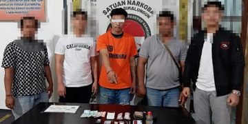 Tersangka bersama petugas di Polres Simalungun