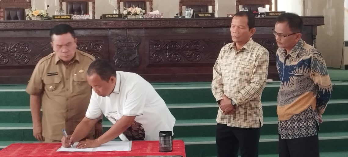 Ketua DPRD Siantar tandatangani  lembaran Perda, disaksikan Wakil Ketua DPRD  dan Walikota