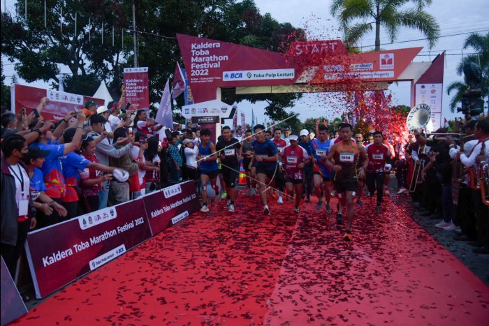 Sejumlah peserta berlari pada Kaldera Toba Marathon Festival 2022 di Balige, Toba, Sumatera Utara, Minggu (27/11/2022). Lari marathon yang diselenggarakan Pemkab Toba tersebut diikuti sekitar 1.400 peserta dari berbagai daerah di Indonesia dengan tujuan mempromosikan potensi wisata Danau Toba. (ANTARA FOTO)