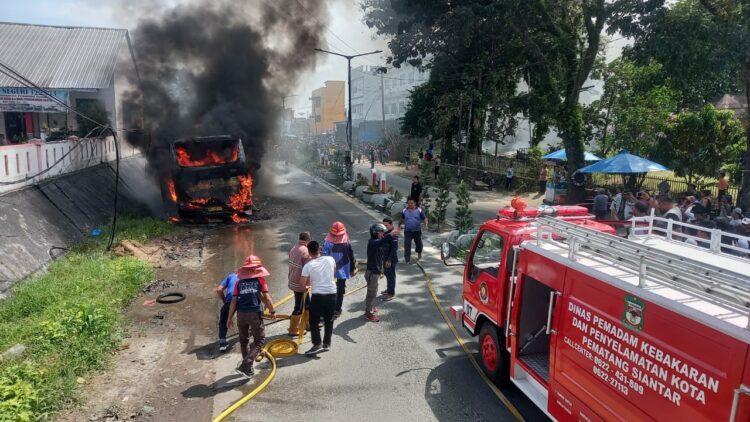 Disdamkarmat Kota Pematang Siantar Padamkan Kebakaran Bus Nice Trans di Jalan Sisingamangaraja, Kelurahan Sigulang-gulang, Kecamatan Siantar Utara, Sabtu (09/12/2023).