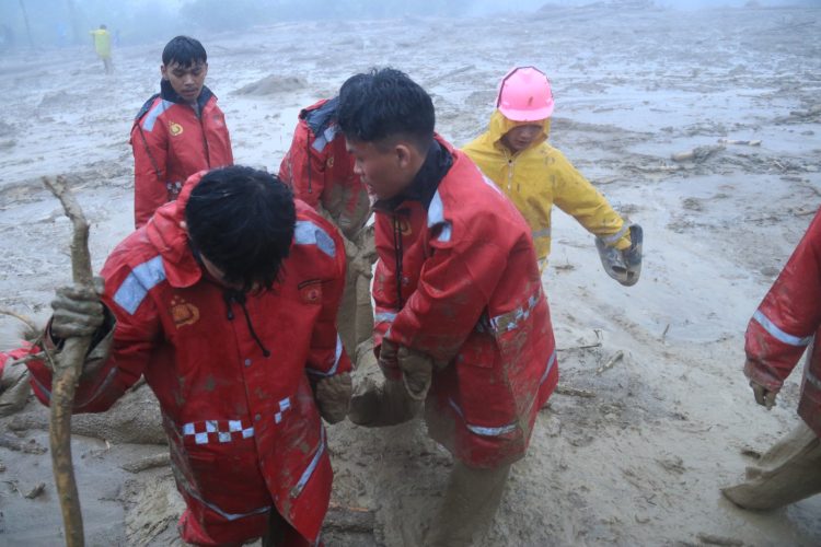 Personel polisi bersama tim gabungan mengevakuasi korban banjir bandang di Desa Panggugunan, Kecamatan Pakkat, Humbang Hasundutan. Proses evakuasi dilakukan di tengah curah hujan tinggi dan kondisi medan yang tertutup material lumpur.