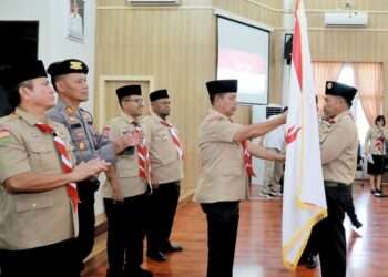 Bupati Simalungun RHS, memberikan bendera merah putih saat pemberangkatan Kontingen Pramuka ke Cibubur.