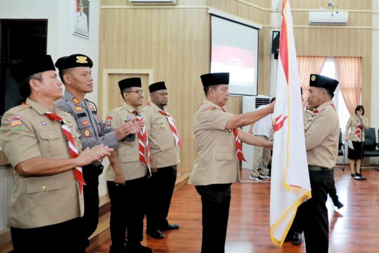 Bupati Simalungun RHS, memberikan bendera merah putih saat pemberangkatan Kontingen Pramuka ke Cibubur.