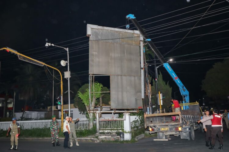 Personel Satpol PP Kota Pematang Siantar, membongkar paksa reklame milik CV Trimedia, di Jalan Sangnaualuh Damanik Simpang Sambo, Kelurahan Siopat Suhu, Kecamatan Siantar Timur, karena tidak memiliki Izin Kelayakan Media Reklame.