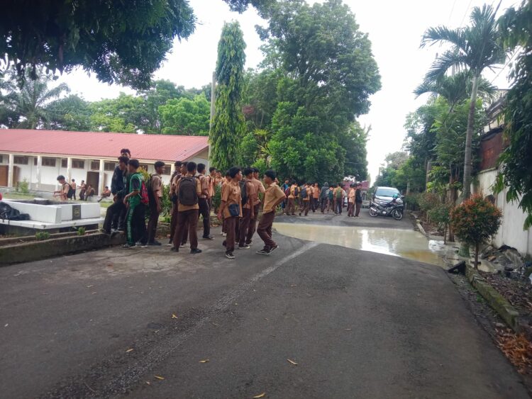 Diduga air limbah pabrik mie menggenangi badan jalan yang amblas sehingga aktivitas pelajar SMK Negeri 2 Pematangsiantar terganggu.