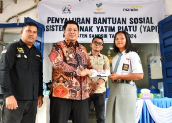 Bupati Samosir Vandiko T Gultom, menyerahkan simbolis bantuan kepada siswa.