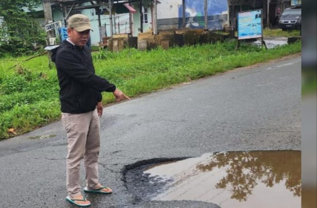 Politisi dari Fraksi PAN Agus Sartono menunjukkan lokasi jalan berlubang, Minggu (23/2/2025)