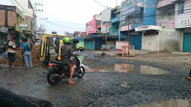 Truk Bermuatan Singkong Terguling di Kubangan Jalan Sudirman Terbanggi Besar