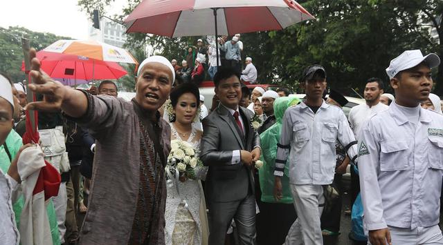 Di Tengah Aksi 112, Anggota FPI Ini Payungi dan Kawal Calon Pengantin Menuju Gereja Katedral