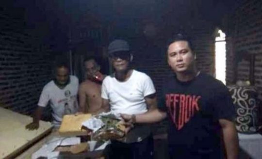 Petugas Ditresnarkoba Polda Lampung (kaos hitam) bersama Kades Natar, Edy Suspondo (kaos putih bertopi) dan warga saat menggeledah rumah kontrakan yang dijadikan tempat untuk menyimpan 400 Kg ganja.