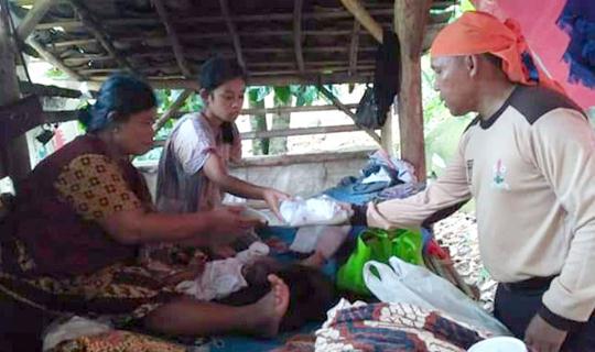 Anggota DPRD Provinsi Lampung dari Fraksi PKS, Antoni Imam, SE saat memberikan bantuan perlengkapan bayi Nova kepada ibunya, Sunenti di tempat pengungsian di sebuah gubuk di lereng kaki Gunung Rajabasa. 