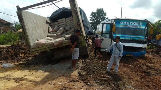 Terjebak di Kubangan Lumpur, Truk Muatan Semen Lumpuhkan Jalan Nasional Rawajitu