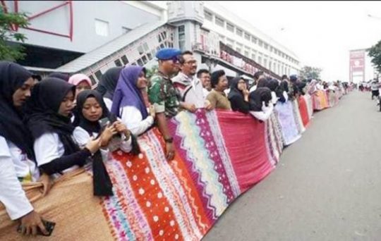 Jokowi dan Kaum Milenial Bentangkan Kain Jumputan Terpanjang di Atas Jembatan Ampera