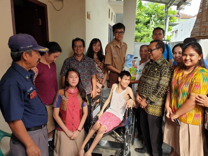 Maruba Siahaan mencoba kursi roda baru sumbangan OSIS SMA Xaverius Bandarlampung.