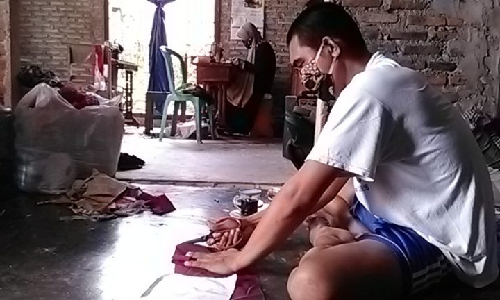 Mbah Yati bersama anak menantunya bernama Sugiarto, tengah mengerjakan pesanan masker yang dibuat dari aneka jenis kain perca.