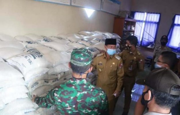 Plt. Budi Utomo memeriksa kondis beras yang akan diberikan kepada warga