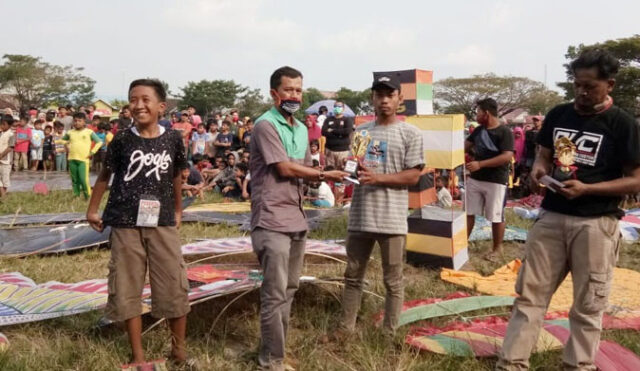 Kepala Desa Sidorejo, Tommy Yulianto didampingi Ketua panitia lomba layang-layang, Budi Santoso atau Hasan menyerahkan hadiah berupa uang tunai dan tropy kepada pemenang lomba, Kamis (23/7/2020) sore.