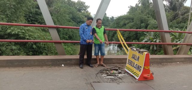  Sekretaris Dinas PUPR Lampung Utara, Rohim Fauzi memasang rambu penanda pada jembatan Way Rarem di Jalintengsum yang rusak parah.