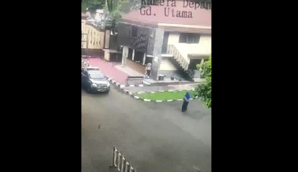 Pelaku berjalan santai menuju pos penjagaan Mabes Polri. Terlihat ia membawa map kuning di tangan kiri.