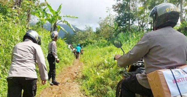 Tim vaksinator Polres Tanggamus, harus menempuh perjalanan ekstrim melewati medan terjal dan licin jalan setapak serta bebatuan dengan kontur perbukitan tak ubahnya seperti ekshibisi offroad, saat menuju wilayah terpencil memberikan vaksin kepada warga di Pekon (Desa) Kampung Baru, Kecamatan Kota Agung Timur, Tanggamus. (Foto: Dok. Humas Polres Tanggamus)